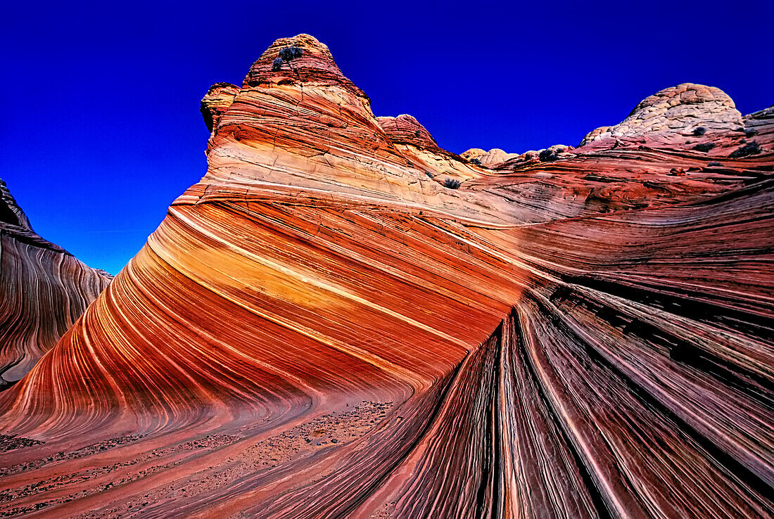 Die spektakuläre Formation mit leuchtenden Farben in Wirbeln aus brüchigem Sandstein ist als The Wave bekannt und befindet sich im Abschnitt Coyote Buttes des Vermilion Cliffs National Monument. Ein unmarkierter Wildnispfad begrenzt Wanderer und erfordert eine Genehmigung des Bureau of Land Management; Arizona, Vereinigte Staaten von Amerika