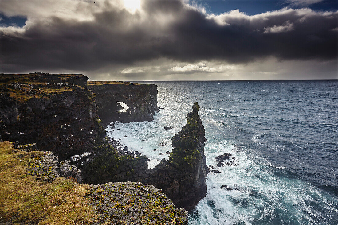 Lava cliffs at Skalasnagi with dramatic storm clouds, at the northwestern tip of the Snaefellsnes peninsula, western Iceland; Iceland