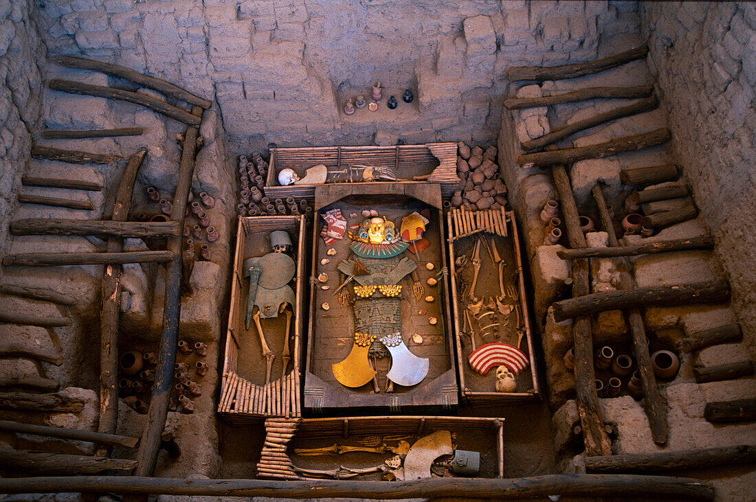 Lord of Sipan, important Moche burial site in Peru. The site was being looted but it was stopped and some tombs are restored with replicas to show what the graves looked like 1500 years ago. The treasure trove discovered included gold, silver, copper and semi-precious stones as well as hundreds of ceramic pots which contained food and drink for journey in the after life..  The Mochica leader was buried in all of this finery along with a warrior guard buried alive (with his feet cut off), three women, two assistants and a servant; Sipan, Peru
