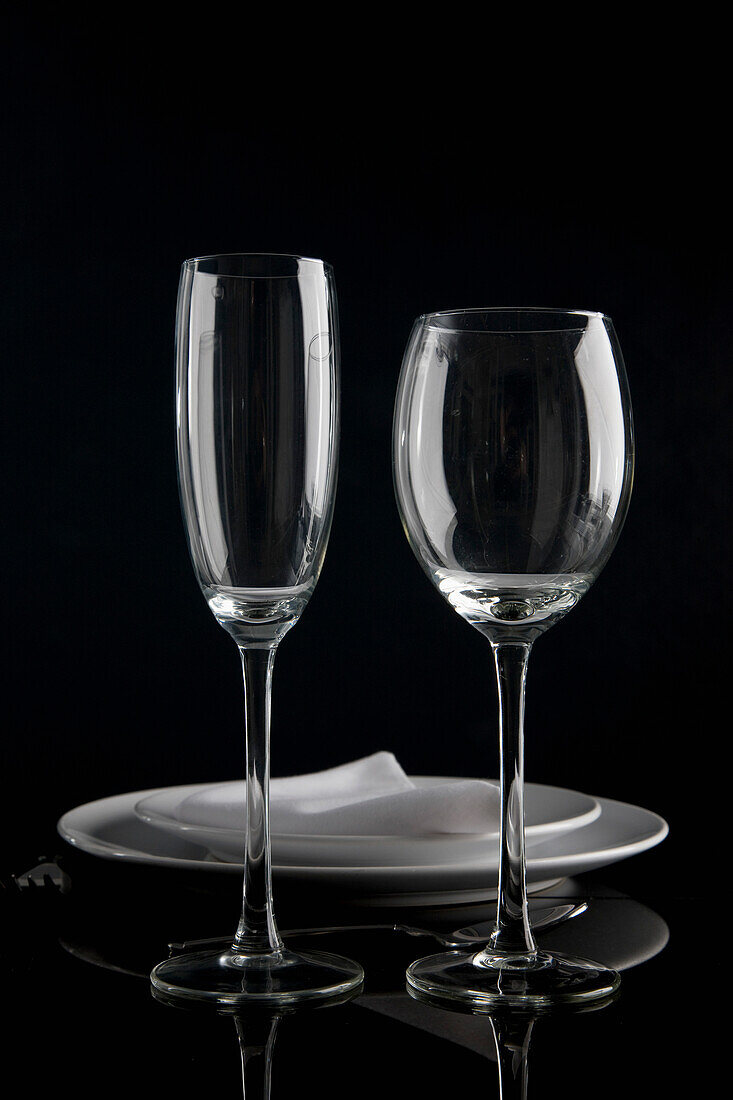 Close up of a place setting with plates napkin and two wine glasses