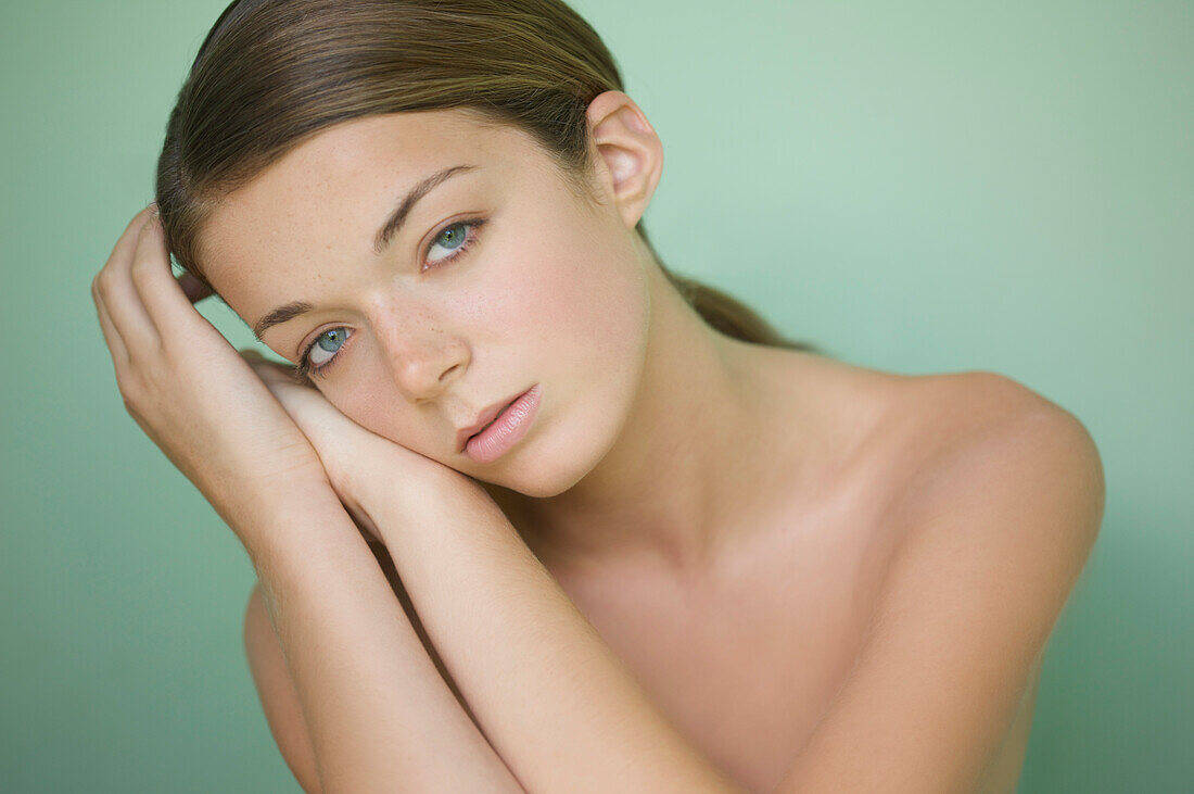 Young woman with face resting on hands