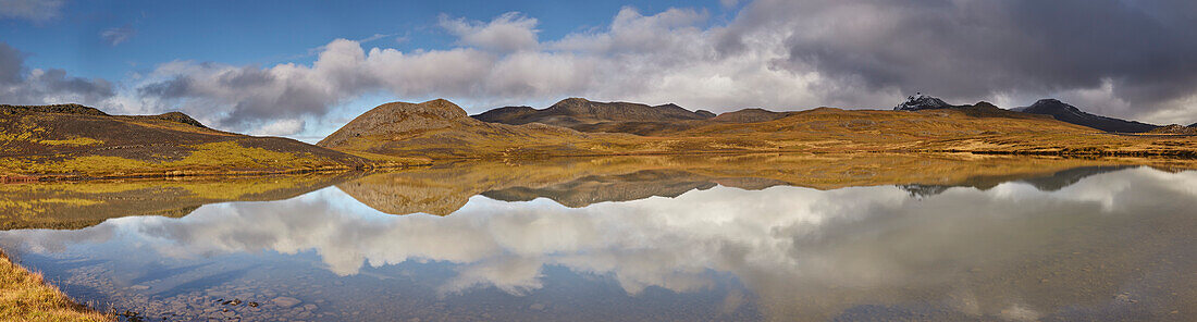 Landformen und Wolkenformationen und ihre Spiegelung in einem See am Valafell-Pass, nahe Olafsvik, Snaefellsnes-Halbinsel, Westküste Islands; Island.
