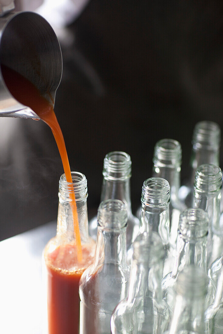 Tomatensoße wird in eine Glasflasche gegossen