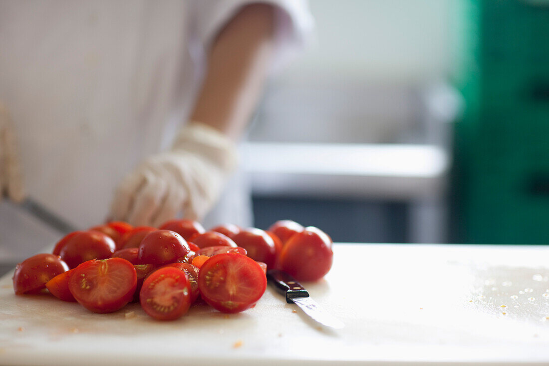 Close up of a worker hands cutting fresh tomatoes