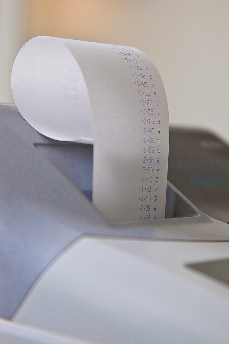 Close up of a cash register with receipt coming out of it