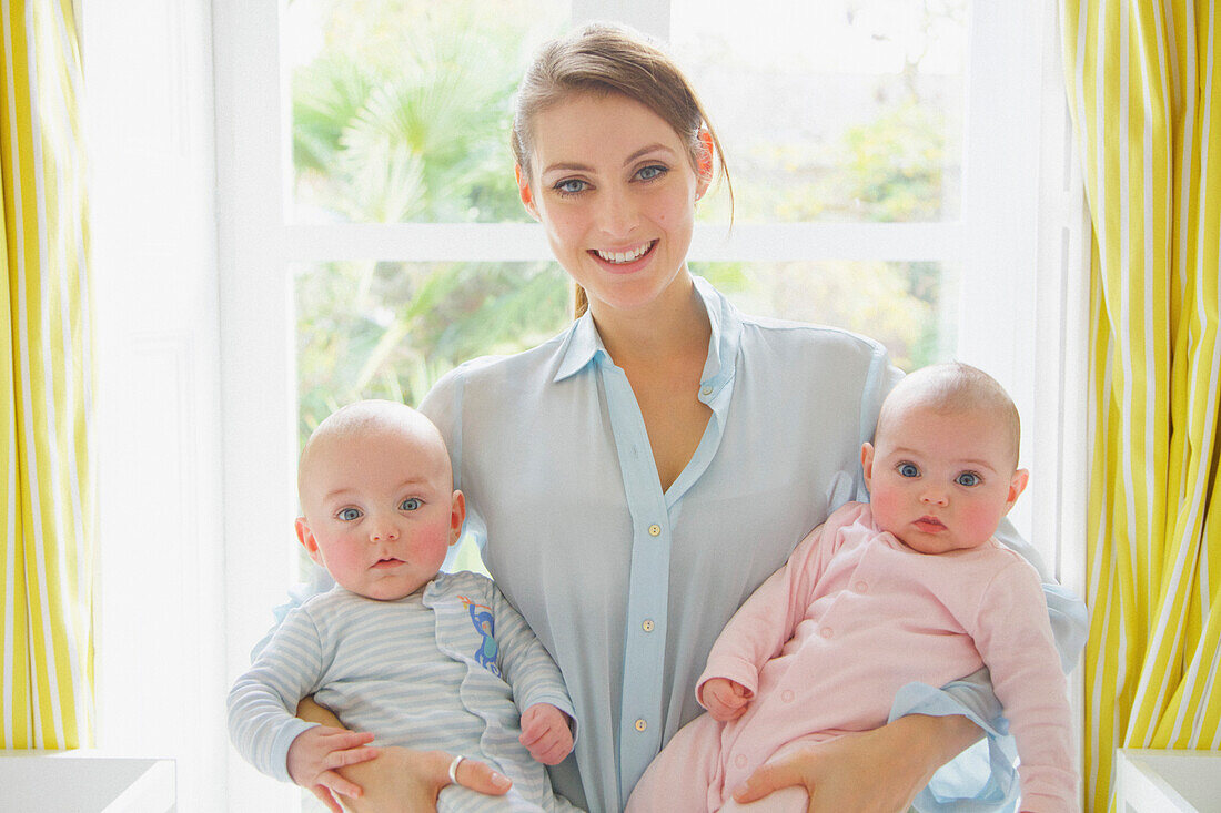 Smiling Mother Holding Twin Babies