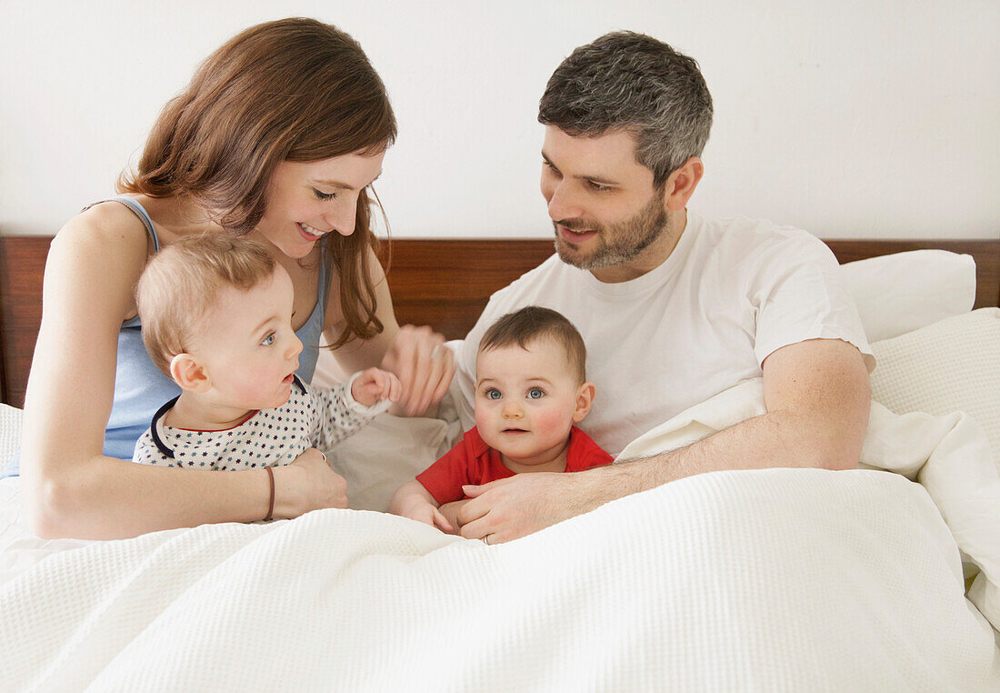 Pärchen im Bett mit Baby-Zwillingen