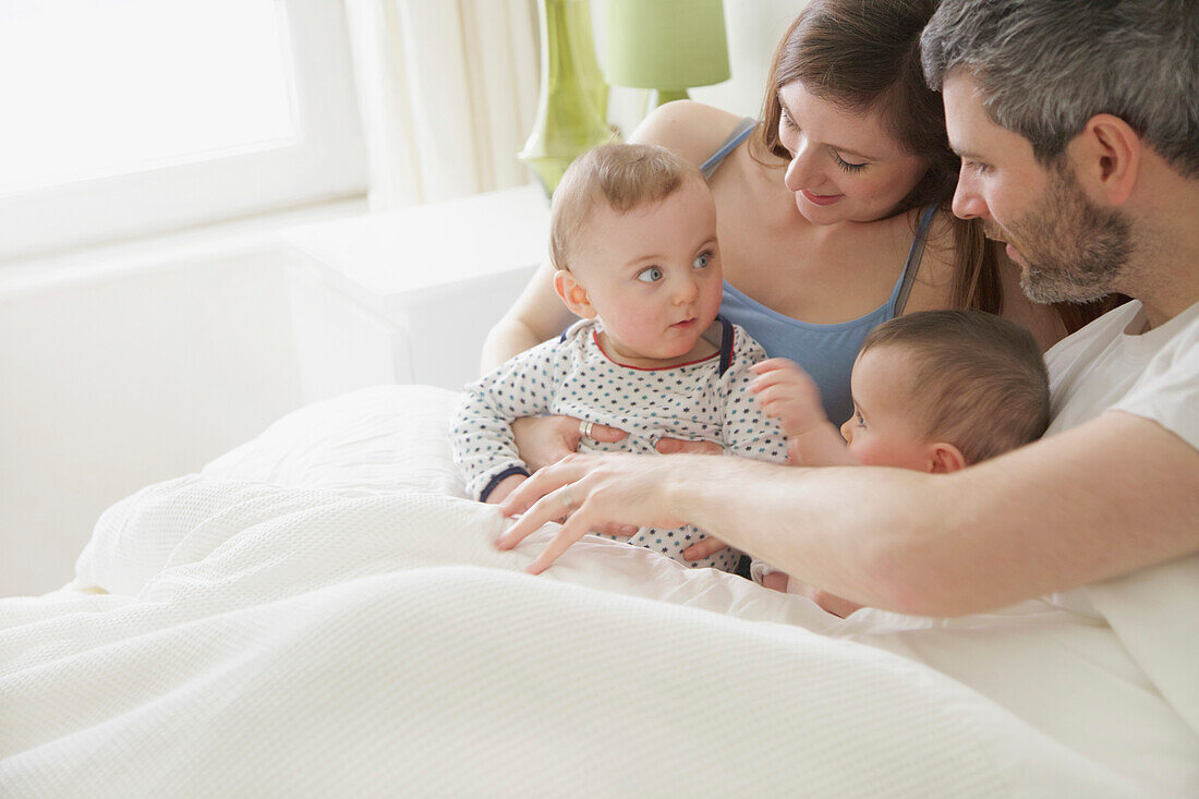 Pärchen im Bett mit Baby-Zwillingen