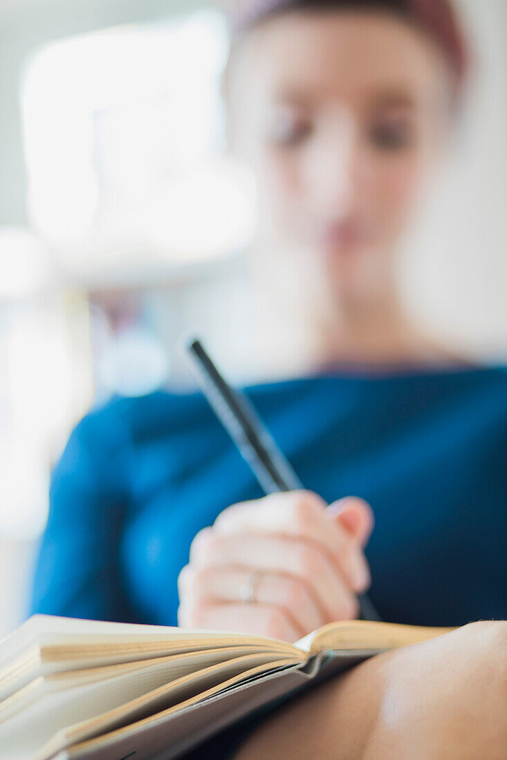 Frau, die auf ein Notizbuch schreibt, Nahaufnahme