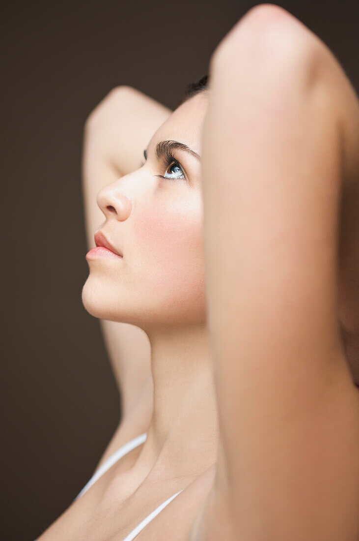 Profile of a woman with her arms crossed behind her head