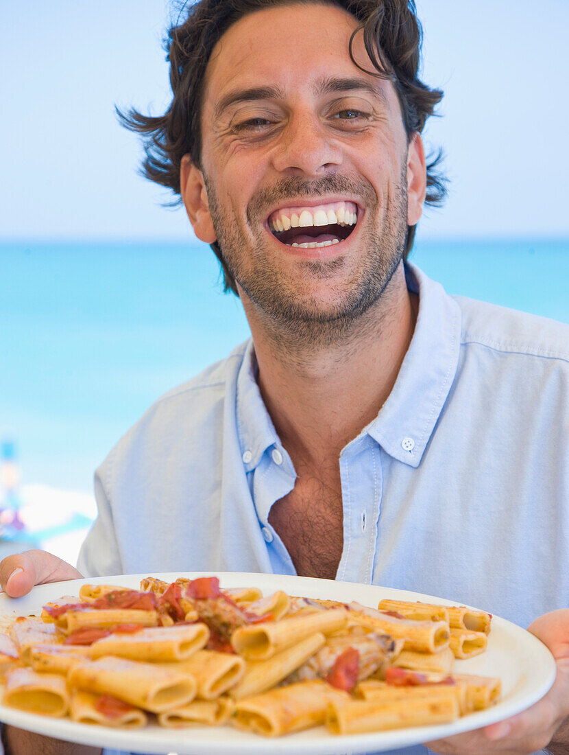 Smiling Man Holding Plate of Ciavattoni Pasta