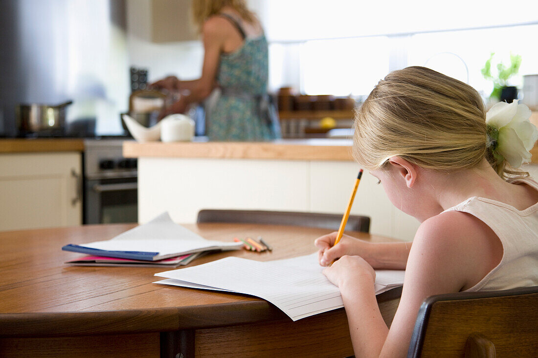 Back View of Young Girl Doing Homework in Kitchen