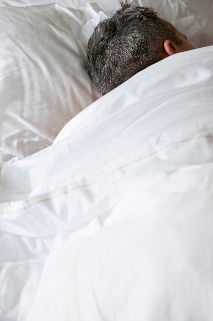 Rückenansicht eines schlafenden Mannes im Bett