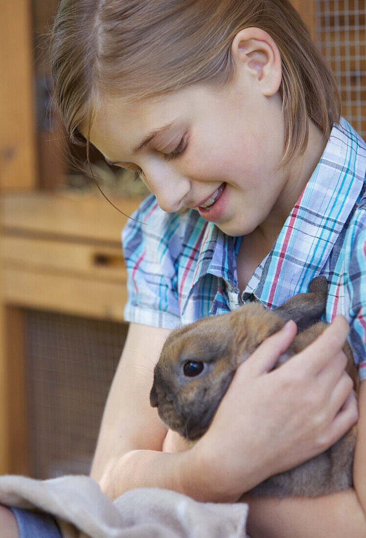 Niedliches Mädchen hält braunes Kaninchen