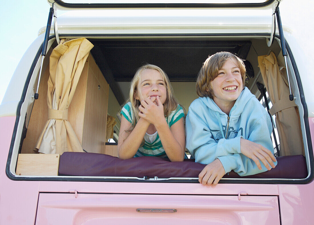 Boy and Girl Looking out of Camper Van Rear Window