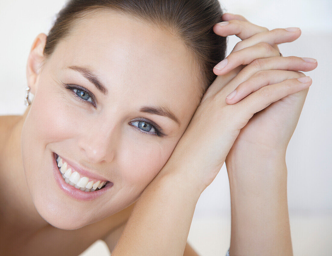 Close up Portrait of Smiling Woman with Head Leaning on Hands