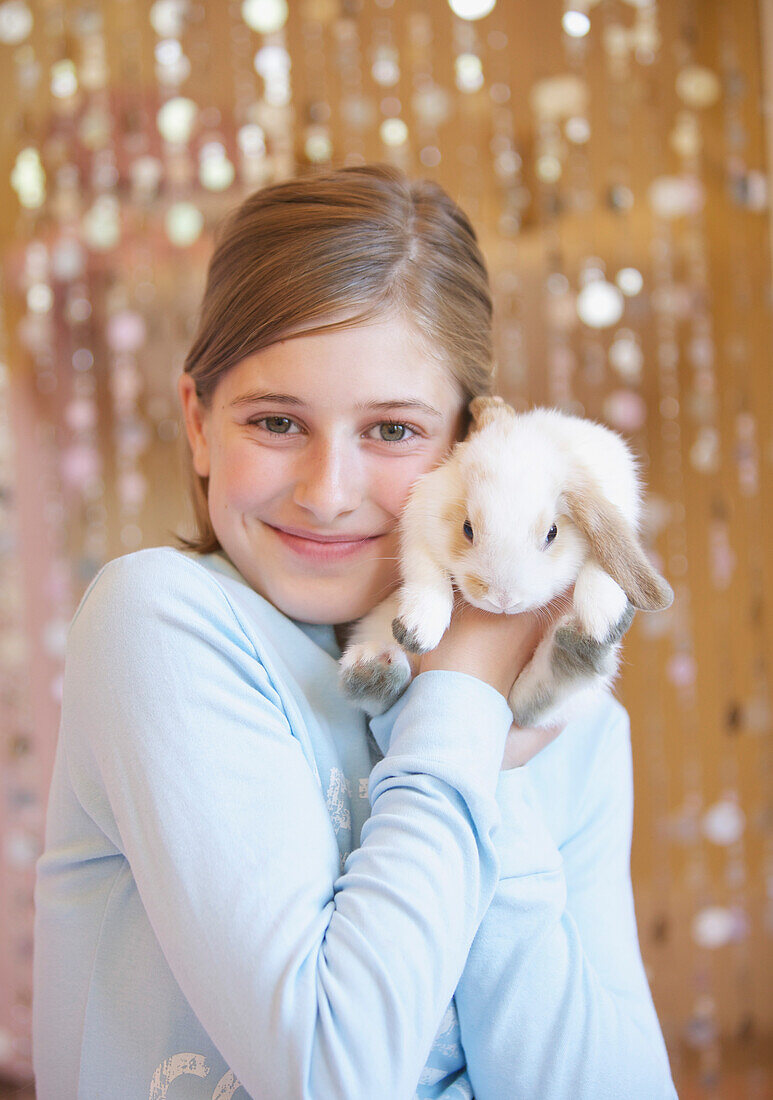 Mädchen hält weißes Kaninchen