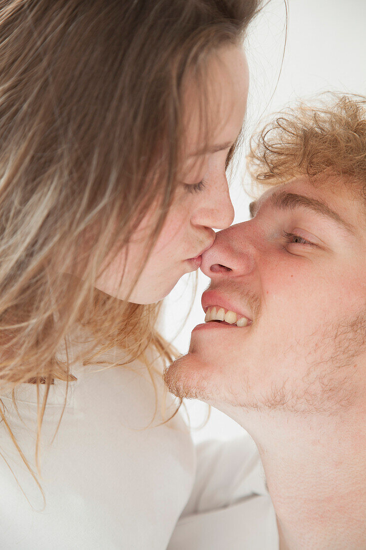 Frau küsst Mann auf die Nase, Nahaufnahme