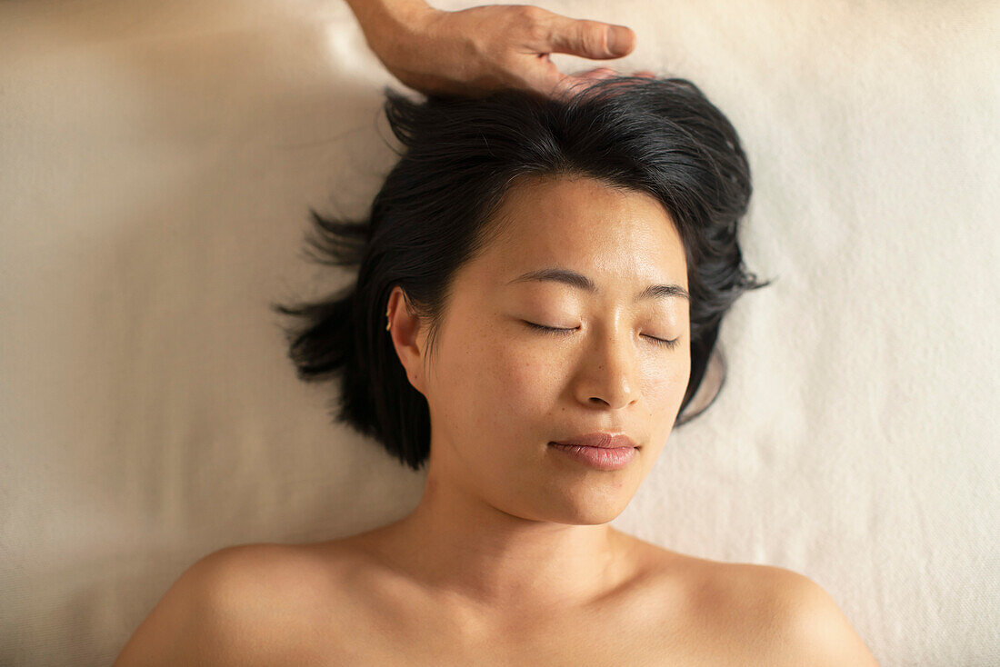 View from above serene woman receiving head massage in spa