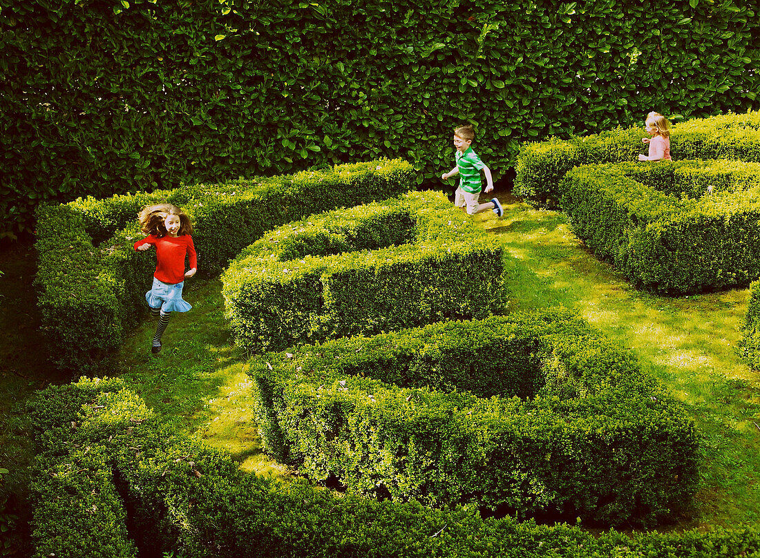 Kinder rennen im Gartenlabyrinth