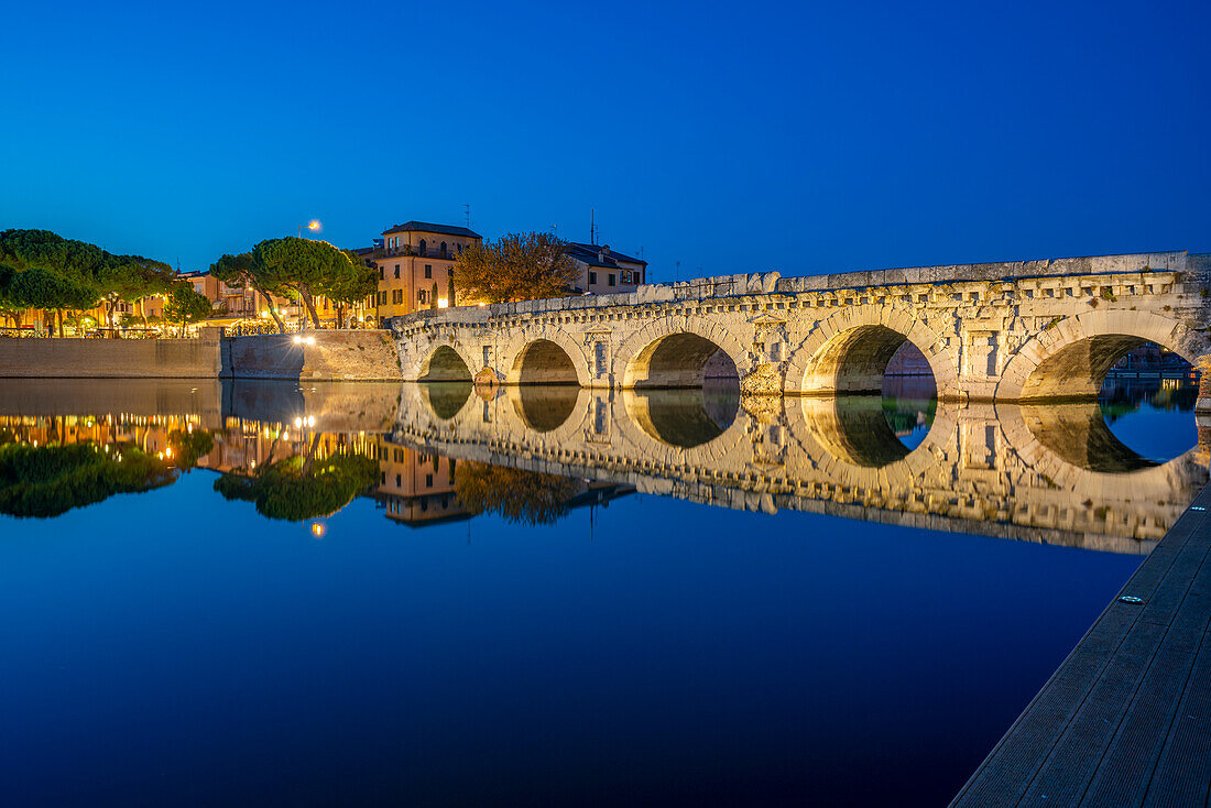 View of Ponte di Tiberio reflecting in Rimini Canal in Borgo San Giuliano district at dusk, Rimini, Emilia-Romagna, Italy, Europe