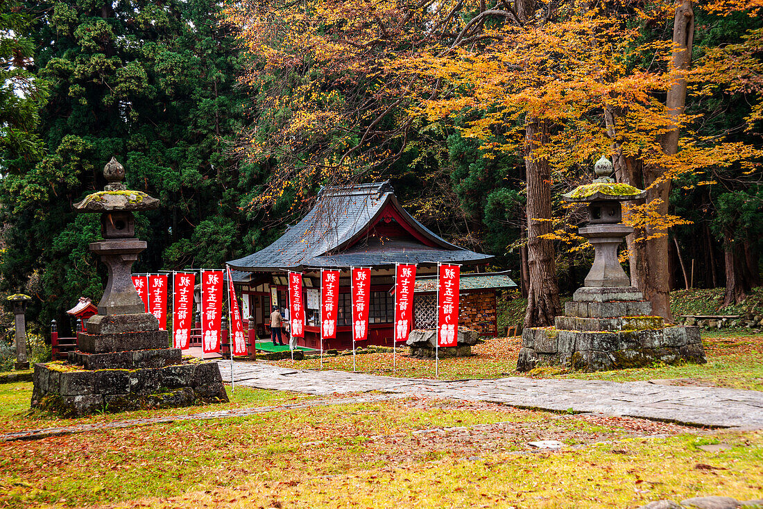 Blick auf einen japanischen Tempel, Steinlaternen in einem herbstlichen Wald, Der Mount Iwaki Schrein, in der Nähe von Hirosaki, Nord Honshu, Japan, Asien