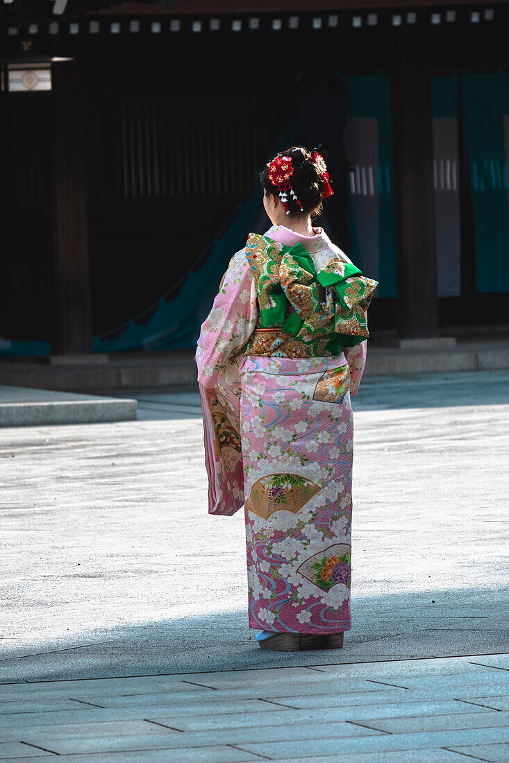 Ein Mädchen in traditioneller Kleidung in einem Tokioter Tempel von hinten gesehen, Tokio, Honshu, Japan, Asien
