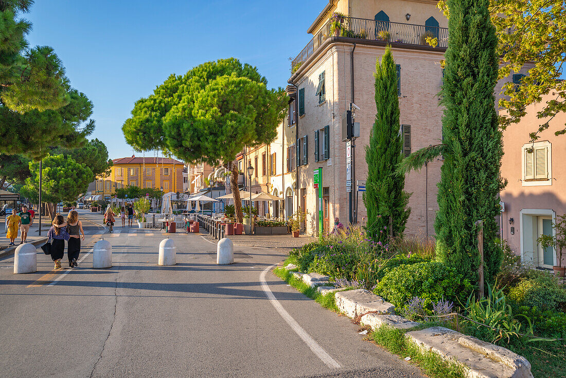 Blick auf bunte Gebäude, Café und Zypressen in Borgo San Giuliano, Rimini, Emilia-Romagna, Italien, Europa