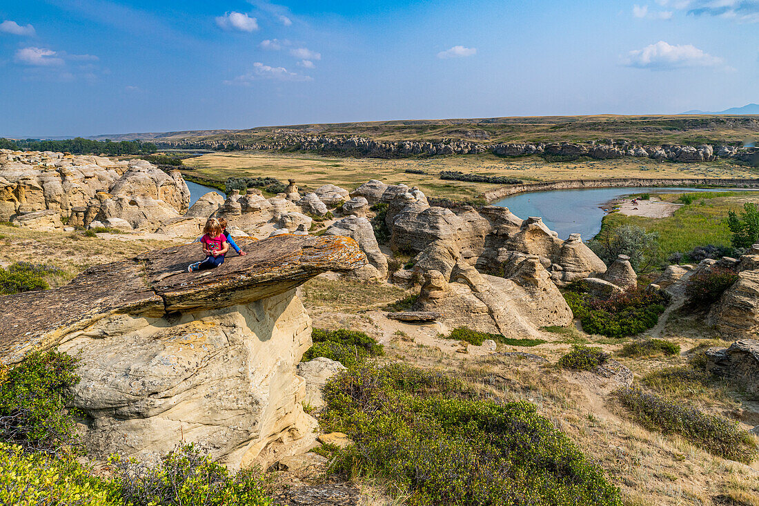 Children playing on a Hoodoo along the Milk River, Writing-on-Stone Provincial Park, UNESCO World Heritage Site, Alberta, Canada, North America