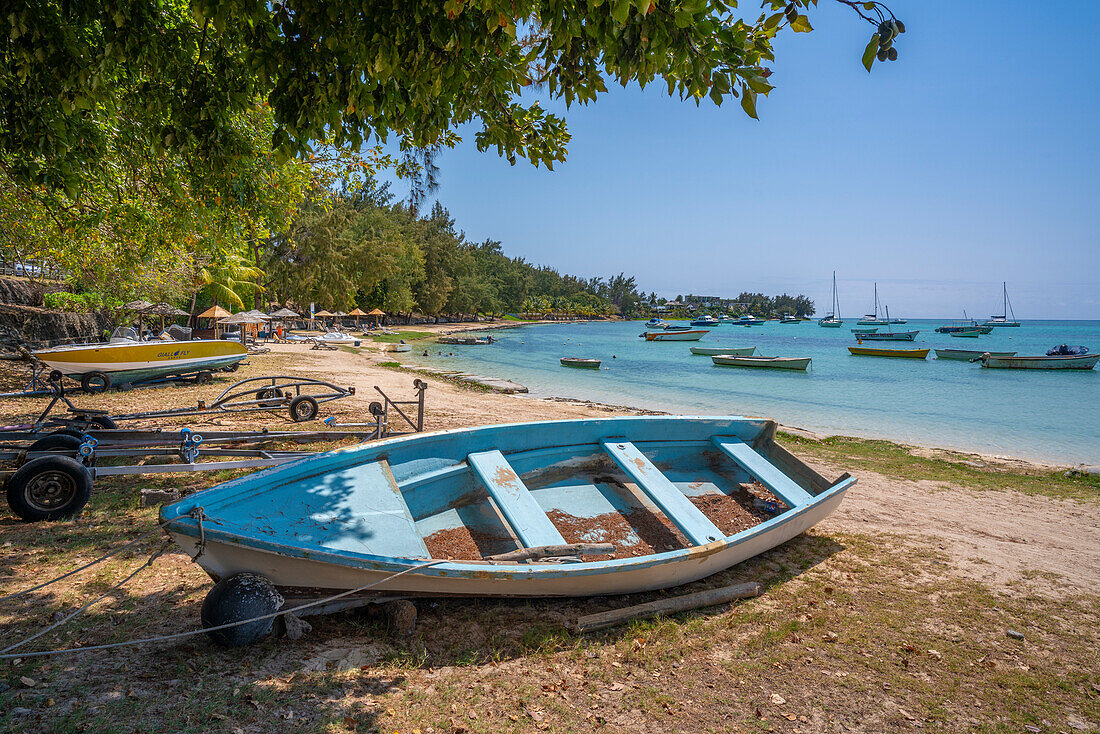 Blick auf ein Boot am Strand und den türkisfarbenen Indischen Ozean an einem sonnigen Tag in Cap Malheureux, Mauritius, Indischer Ozean, Afrika