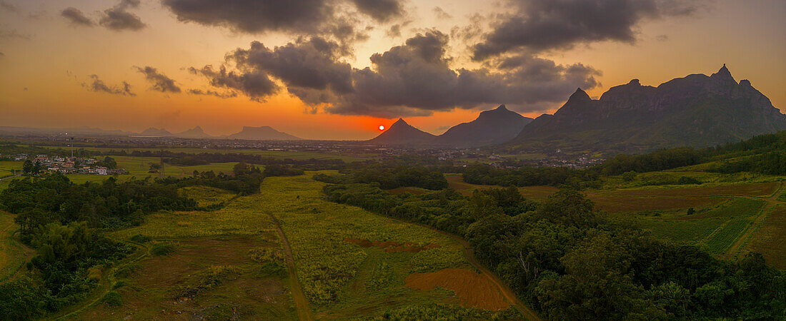 View of golden sunset behind Long Mountain and patchwork of green fields, Mauritius, Indian Ocean, Africa