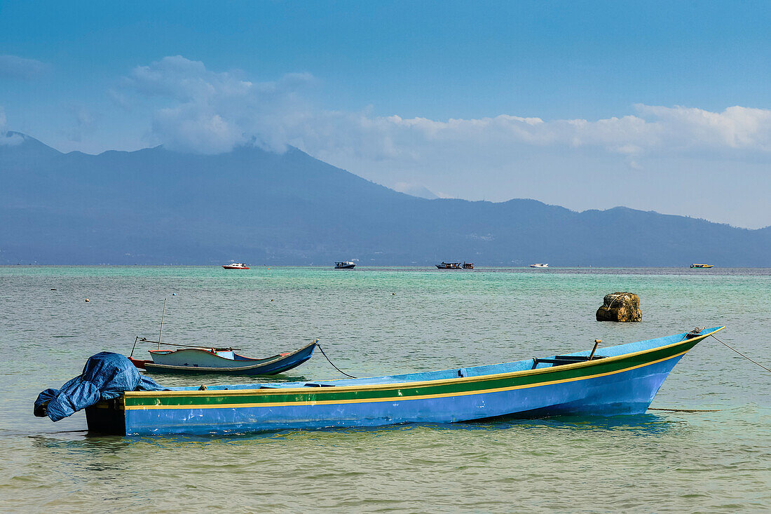 Small boats moored with the mainland beyond, off this coral fringed holiday and scuba diving destination, Bunaken Island, Sulawesi, Indonesia, Southeast Asia, Asia