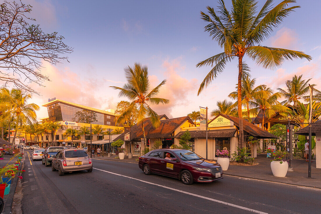 Blick auf Palmen und Boutiquen in Grand Bay bei Sonnenuntergang, Mauritius, Indischer Ozean, Afrika