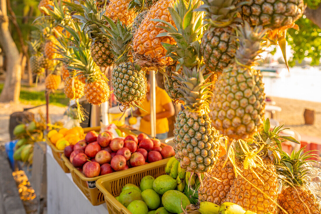 Blick auf Ananas und Äpfel an einem Obststand in Grand Bay zur goldenen Stunde, Mauritius, Indischer Ozean, Afrika