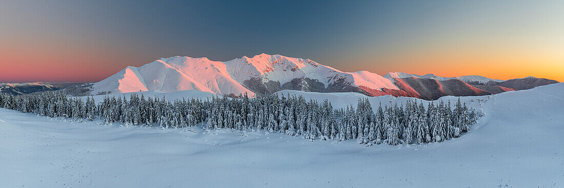 Winterlicher Panoramablick auf das mit Schnee bedeckte Bergmassiv des Viglio bei Sonnenuntergang, Regionalpark Simbruini, Apennin, Latium (Lazio), Italien, Europa