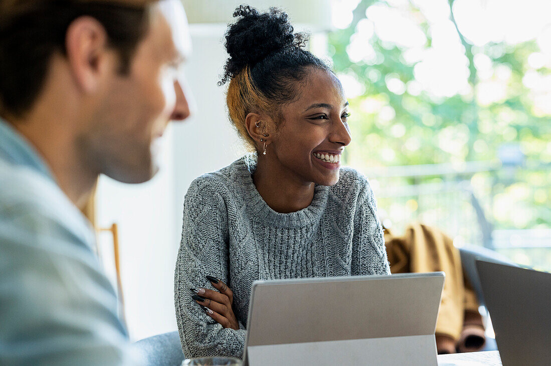 Adult woman smiling during meeting with coworkers