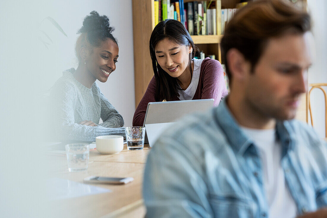 Females coworkers working with laptop on the background