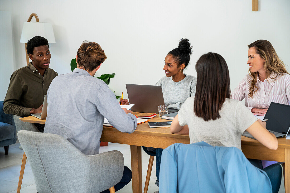 Mitarbeiter im Büro, die an ihren Laptops arbeiten