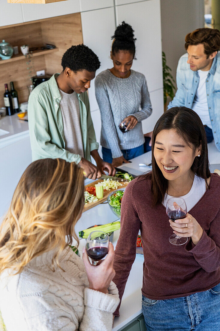 Two friends talking during reunion while drinking wine