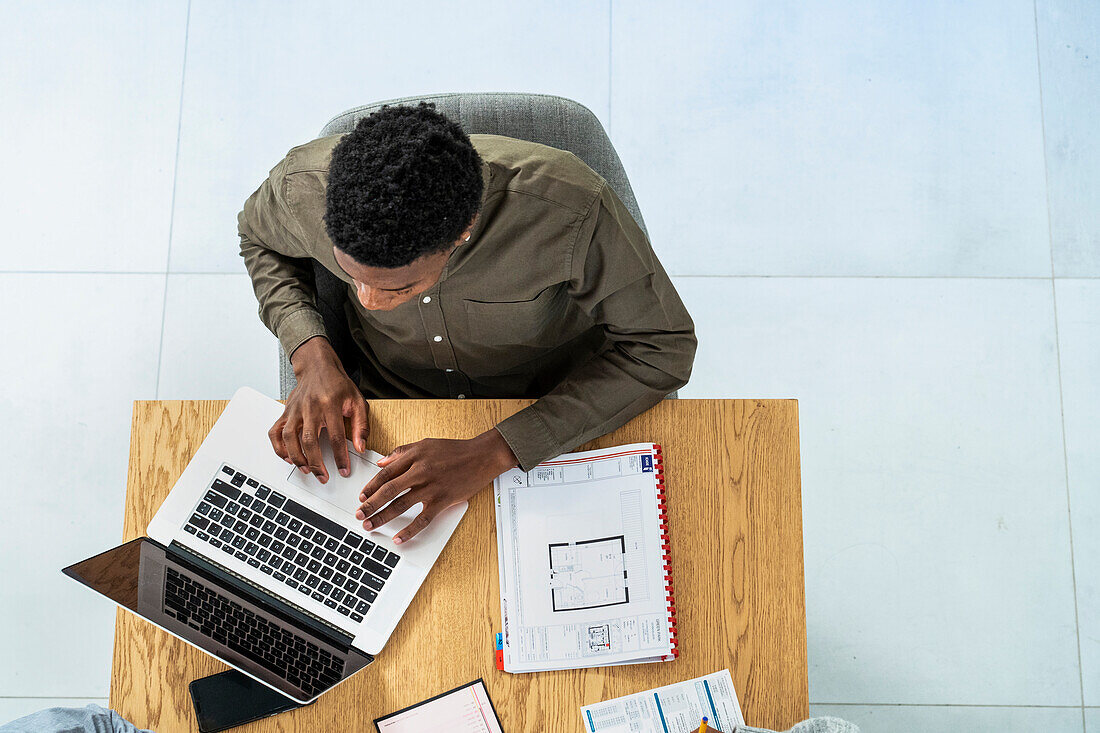 Zenithal view of businessman working on laptop at desk