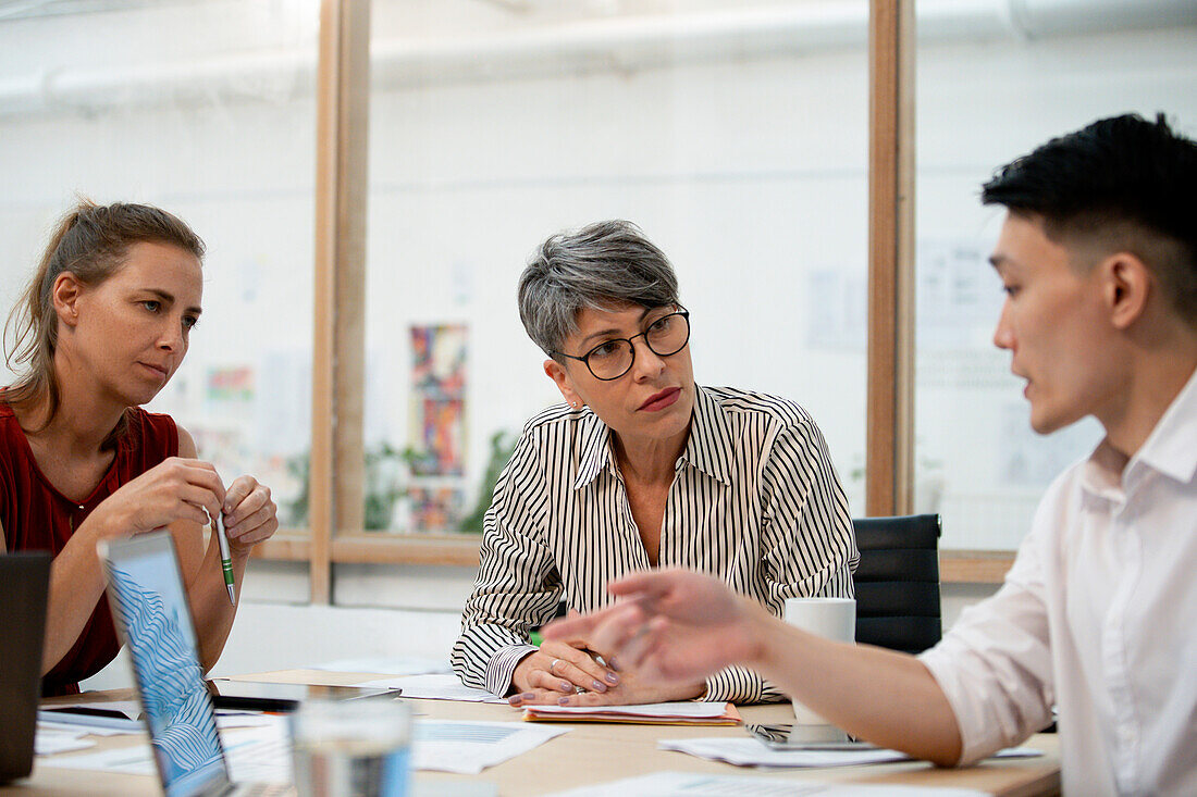 Businesswoman listening to coworkers during project meeting