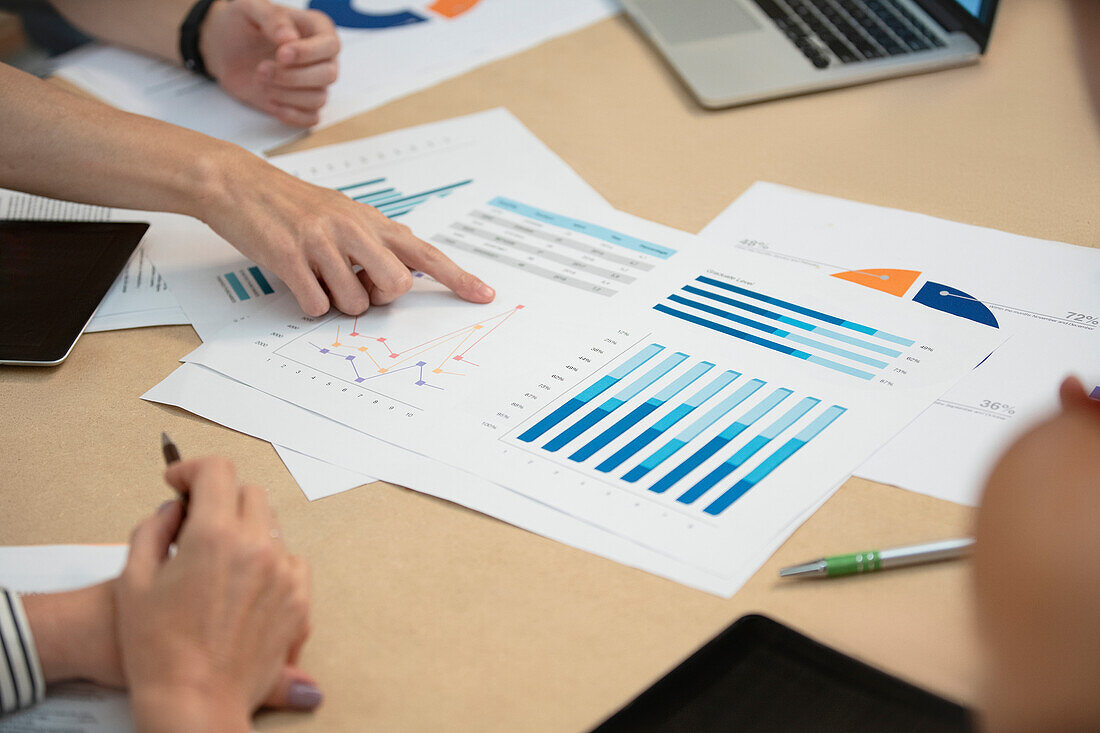 High angle view cropped image of business people working with printed charts