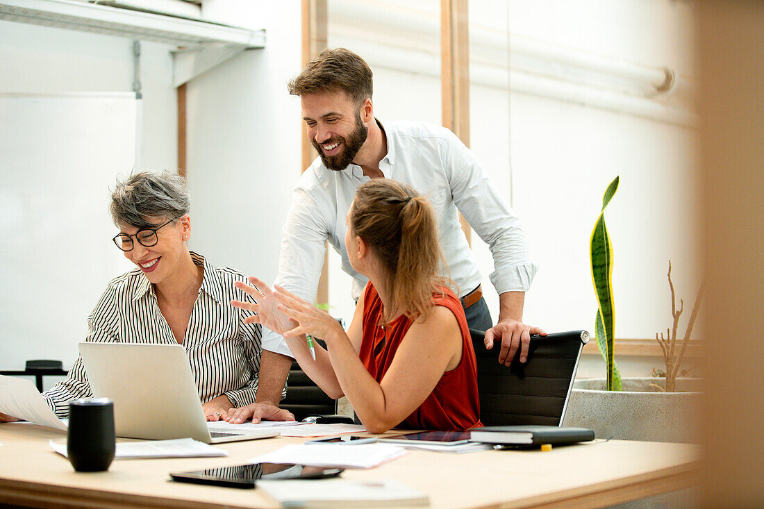 Business group discussing over laptop at work