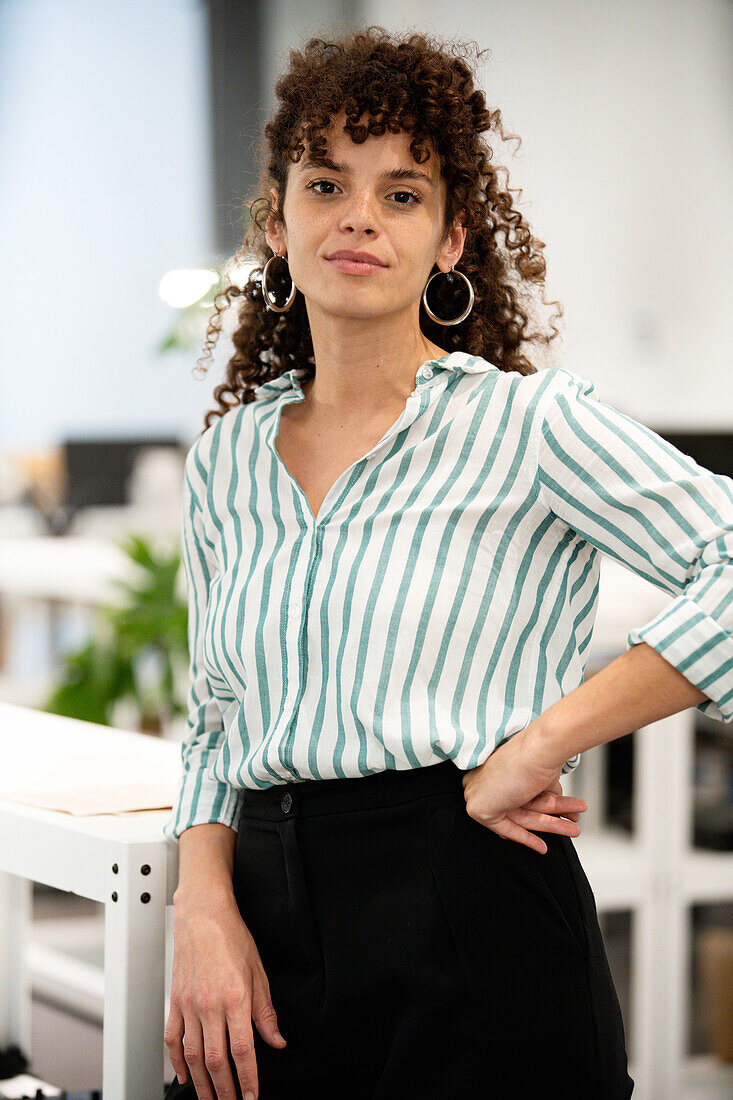 Confident businesswoman standing indoors while looking at the camera