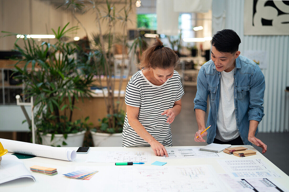 Two architects working on blueprint