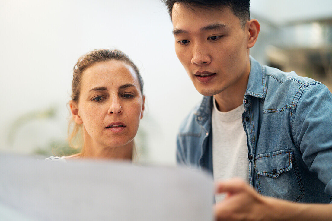 Female architect and male civil engineer looking at blueprint