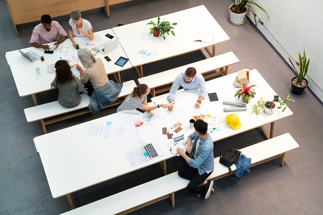 Weite Sicht auf ein Team, das sich im Büro zwanglos trifft