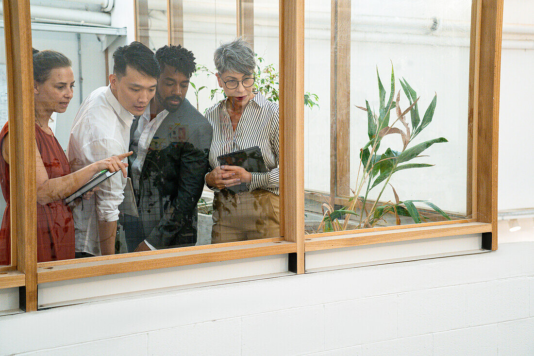 Businessmen and businesswomen discussing while looking down through the window