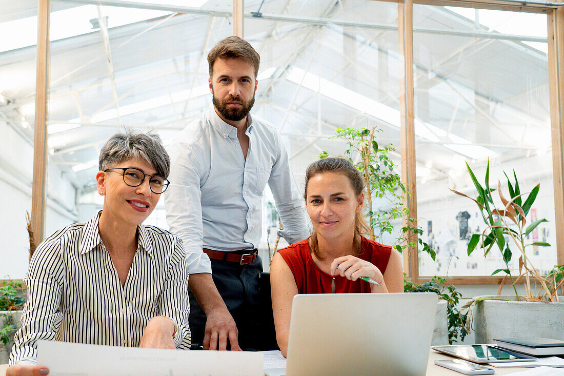 Group of coworkers looking at the camera while working at office