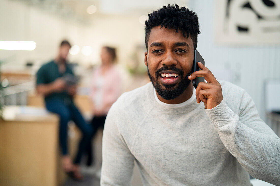 Afroamerikanischer Mann telefoniert mit einem Smartphone